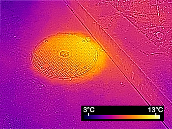 Image thermique d'une grille d'égout qui révèle la chaleur des eaux usées