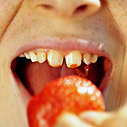 Gros plan sur une bouche qui mange une fraise
