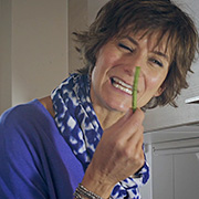 Une femme avec l'air agacé présente un haricot vert