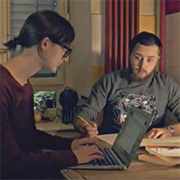 Un jeune couple travaille sur la table de la cuisine