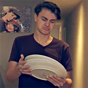Un garçon fait la moue en regardant une pile d'assiettes