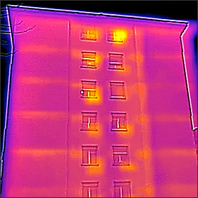 Façade d'un bâtiment vétuste vue en infrarouge. Les dalles créent des ponts thermiques bien visibles.